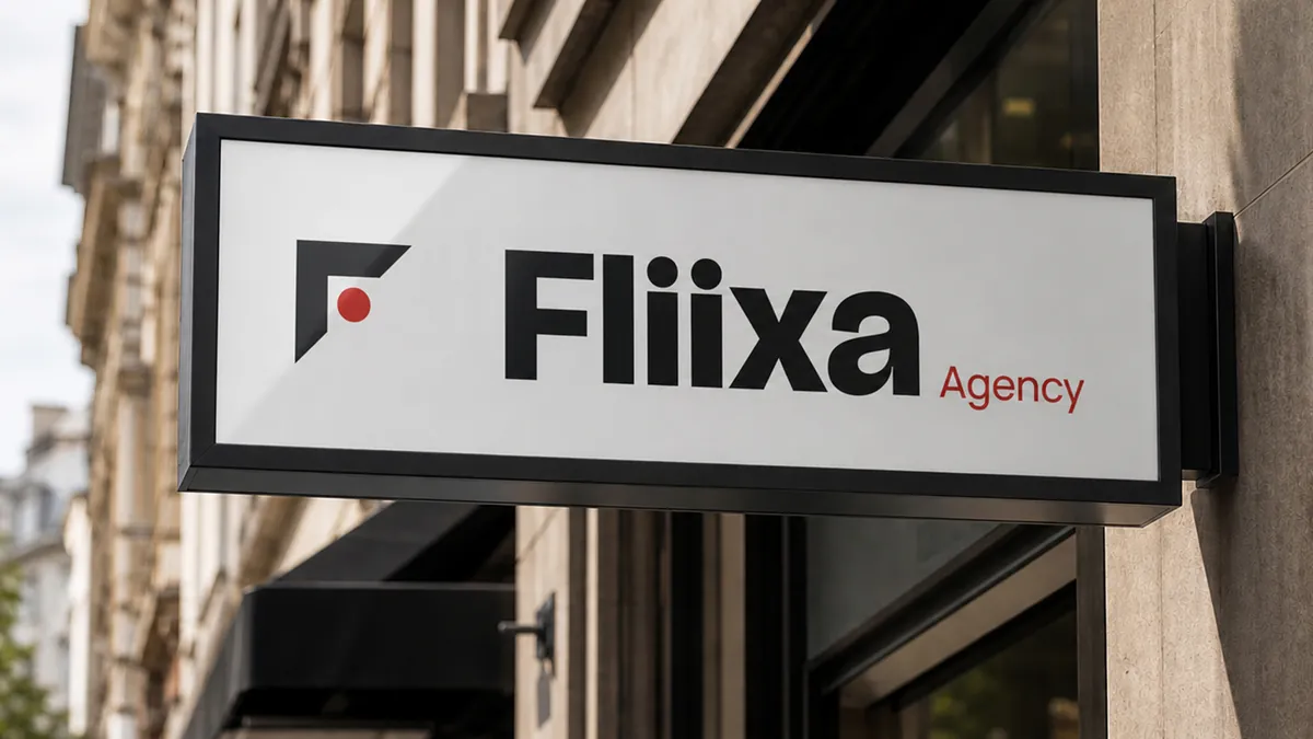 The Fliixa logo on a black-framed projecting sign on a building facade