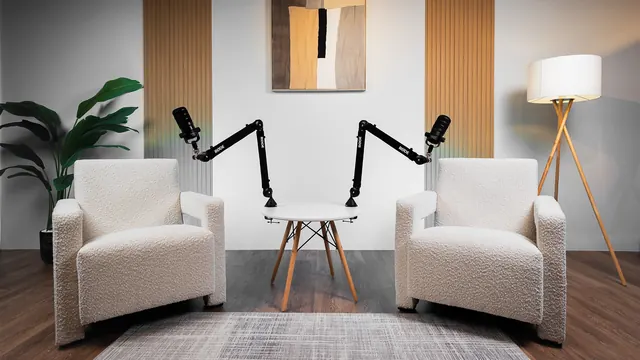 Two white bouclé armchairs with microphones in a light set